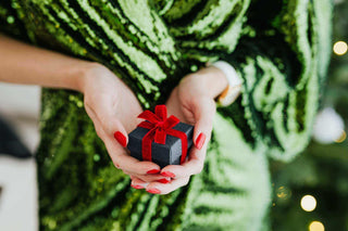 A woman holding a small Christmas present